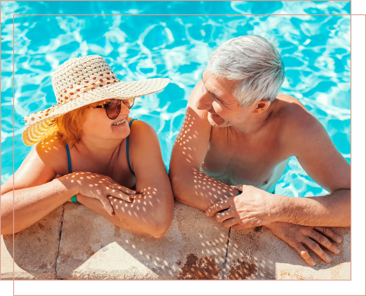 A happy elderly couple enjoying time in a swimming pool.