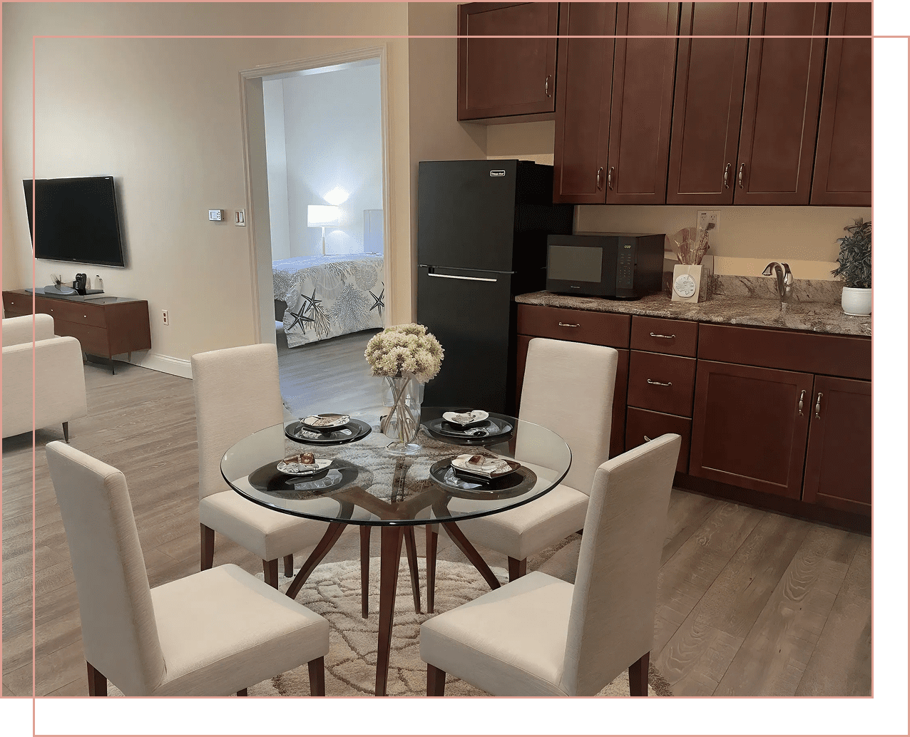 Modern dining area with glass table and white chairs in a bright kitchen.