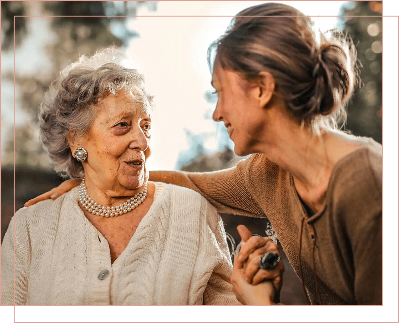 An elderly woman and a younger woman share a warm moment together.