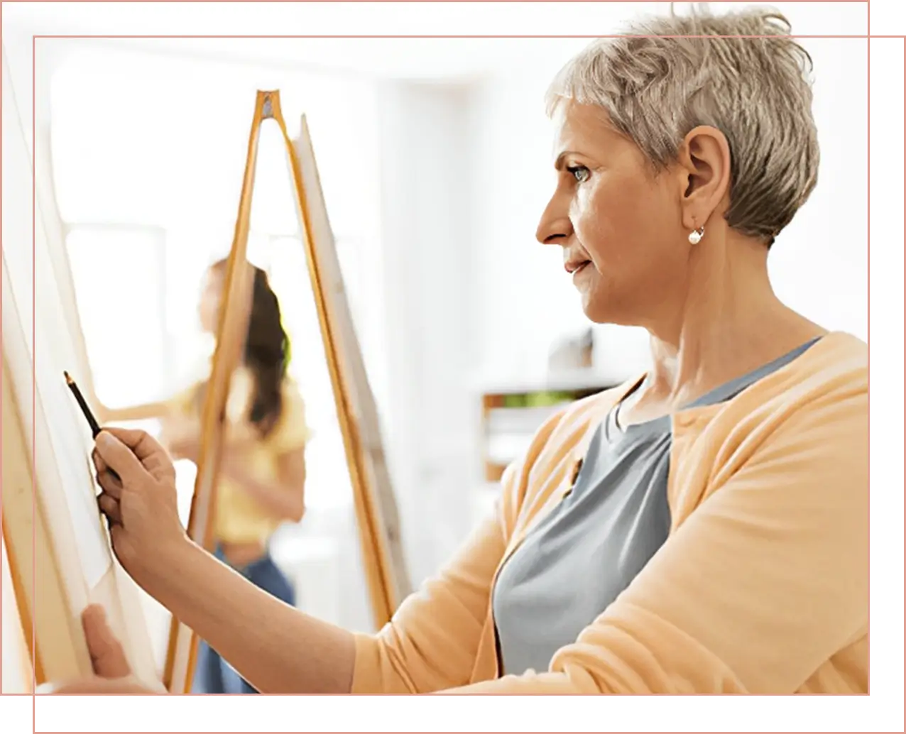 A woman painting on a canvas in a bright room.